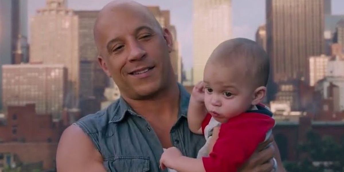 Dom holds his son and smiles in The Fate of the Furious