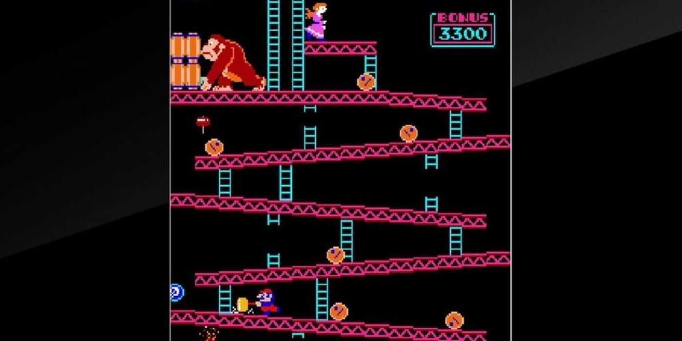 A shot of the video game Donkey Kong with Mario jumping over barrels.