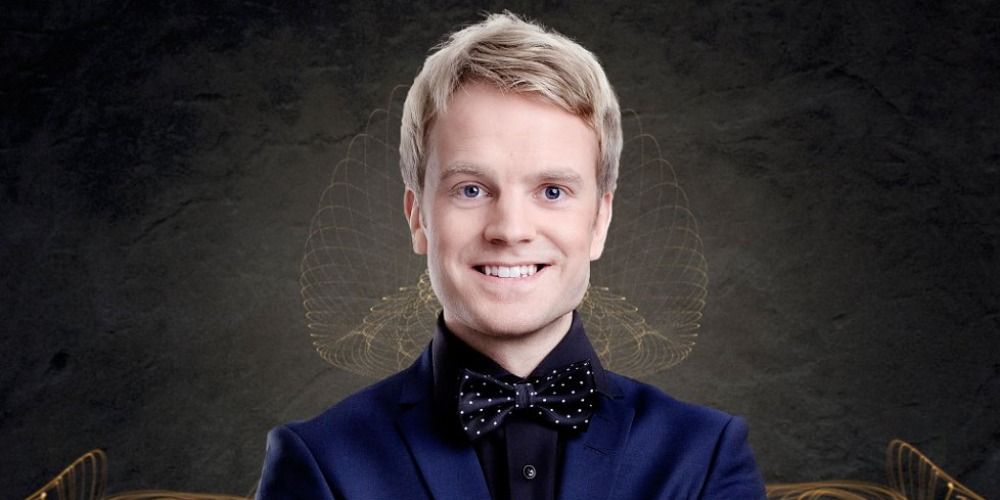 Erik Stolbakken in a promotional image for Eurovision, wearing a black suit and smiling