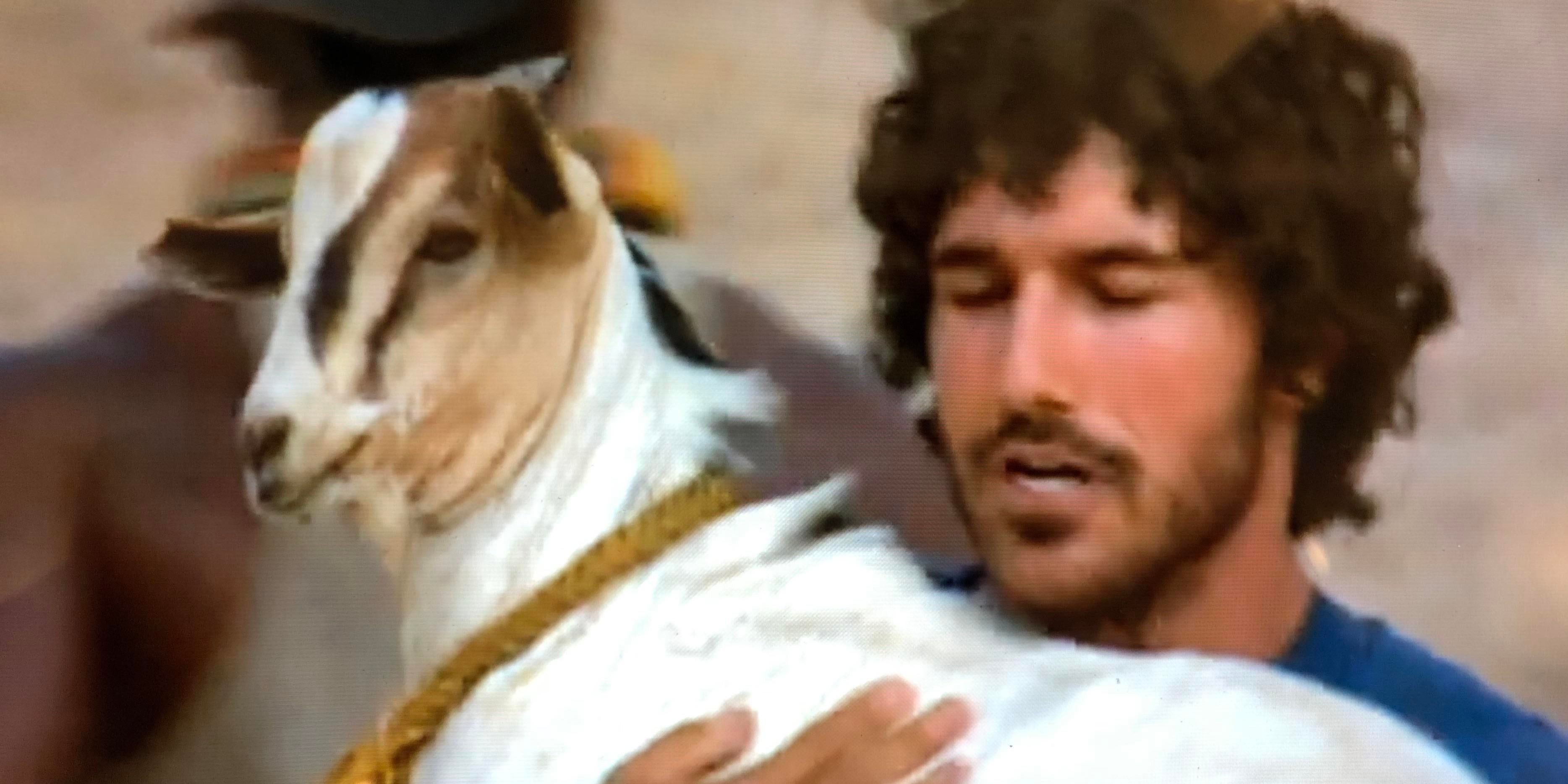 Ethan carrying a goat on Survivor: Africa