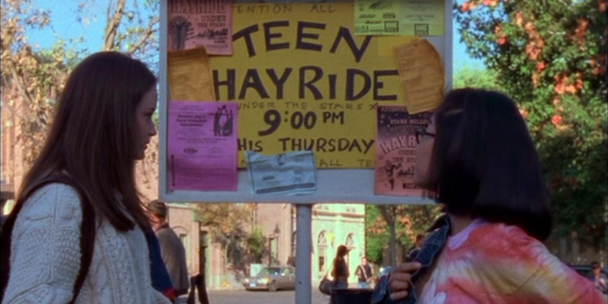 Rory and Lane looking at the Teen Hayride sign
