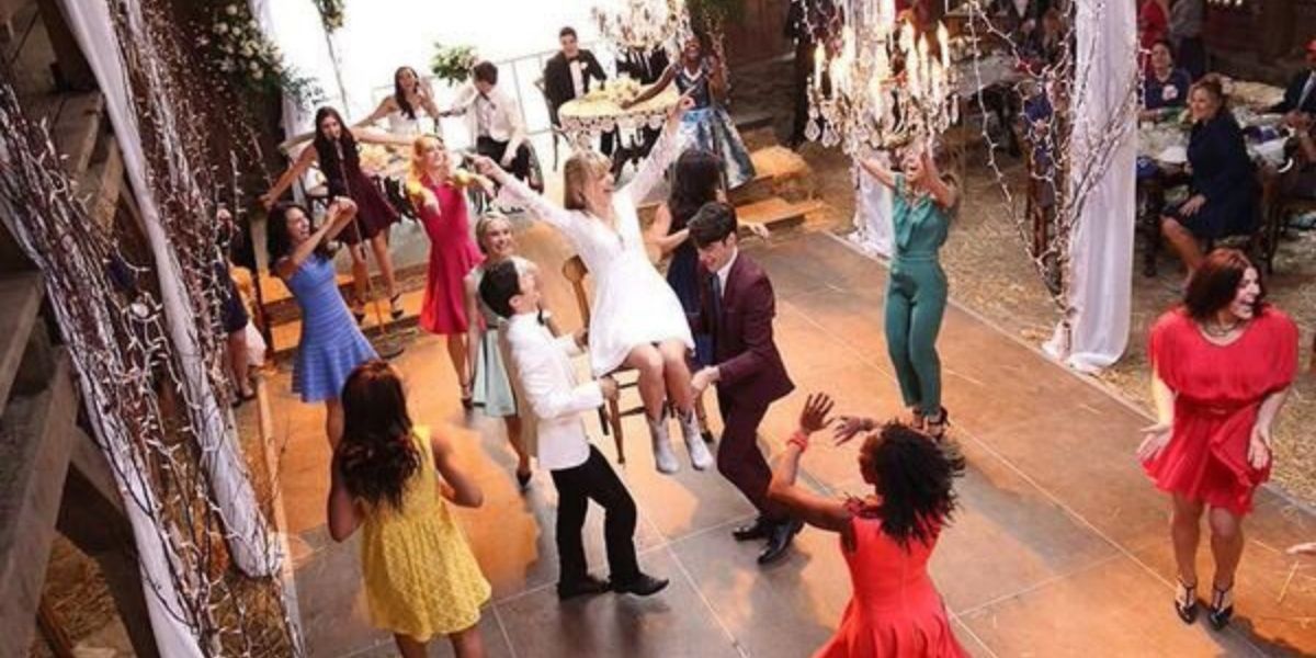 The guests lift Brittany in a chair at her wedding