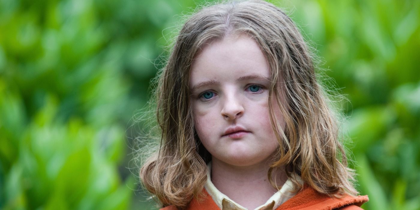 Charlie looks in front of her in a forest in the 2018 film Hereditary.