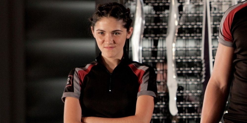 Clove with her arms crossed smiling in The Hunger Games