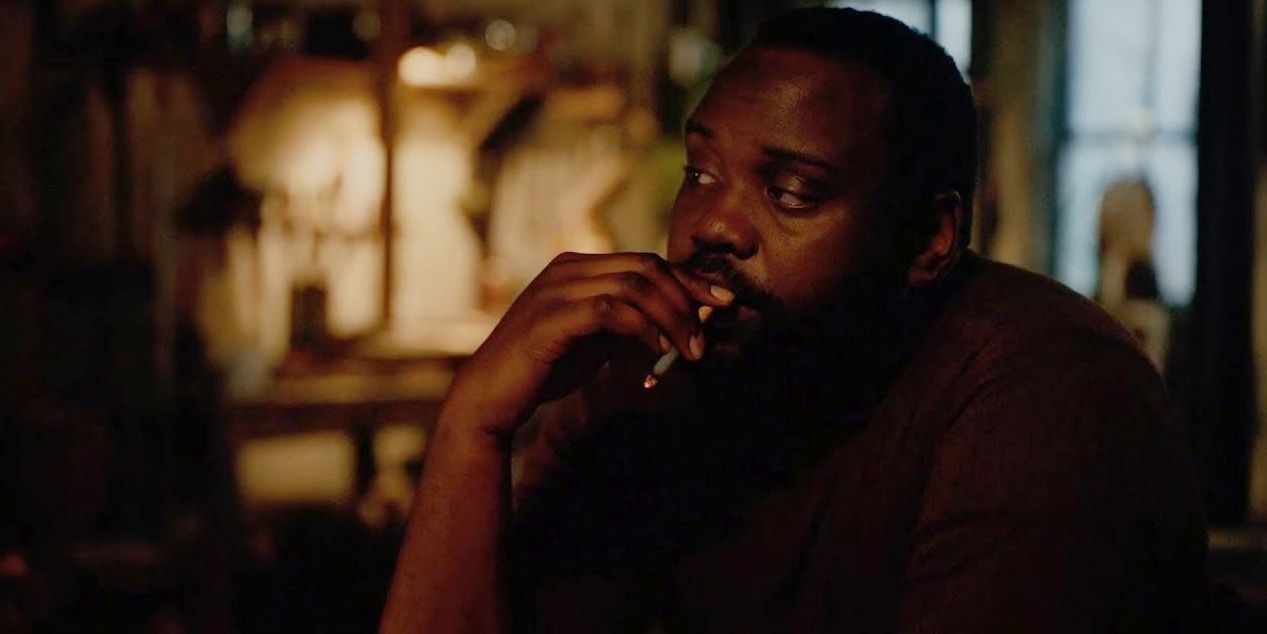 Daniel Carty smoking at Fonny's dining table in If Beale Street Could Talk