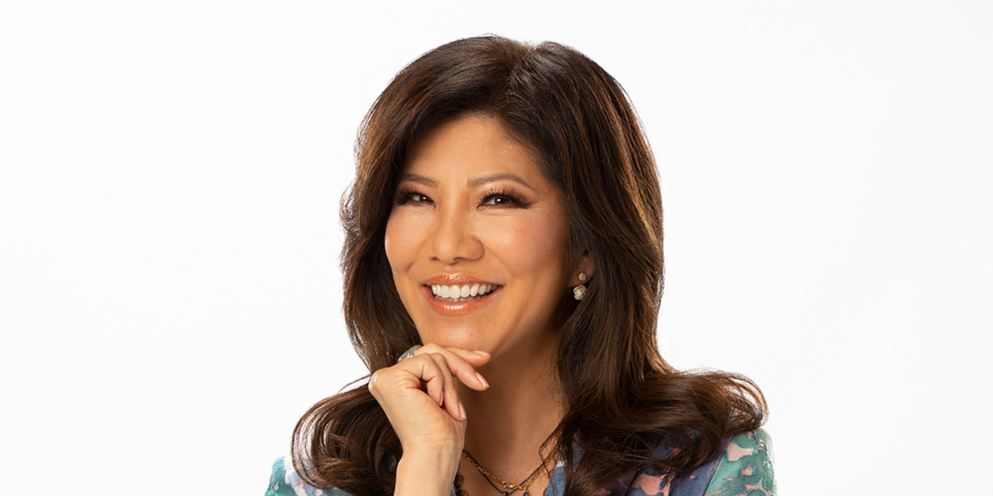 A promotional photo of Julie Chen with her hand on her chin, on a white background.