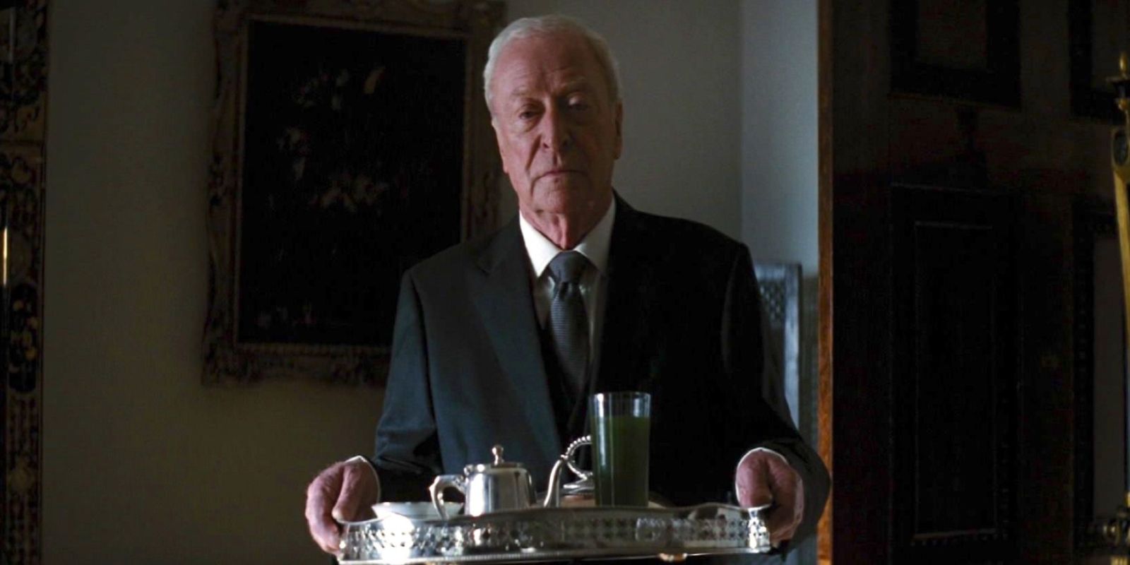 Michael Caine as Alfred holding a tray in The Dark Knight Rises (2012).