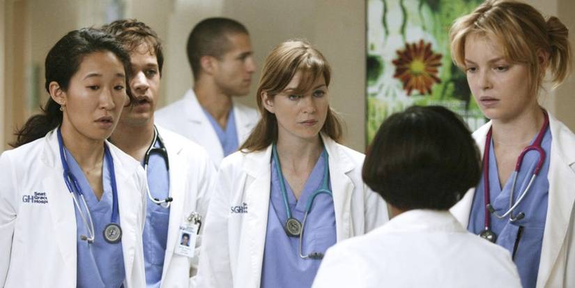 Main cast of Grey's Anatomy talking to Bailey who has her back to the camera