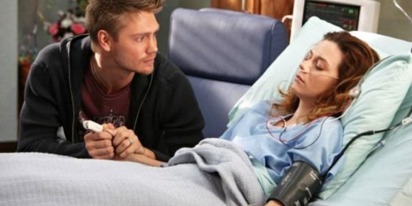 Lucas sitting with Peyton who is lying in a hospital bed on One Tree Hill