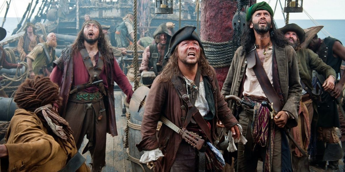 A group of pirates look up in surprise in surprise in Pirates of the Caribbean: On Stranger Tides