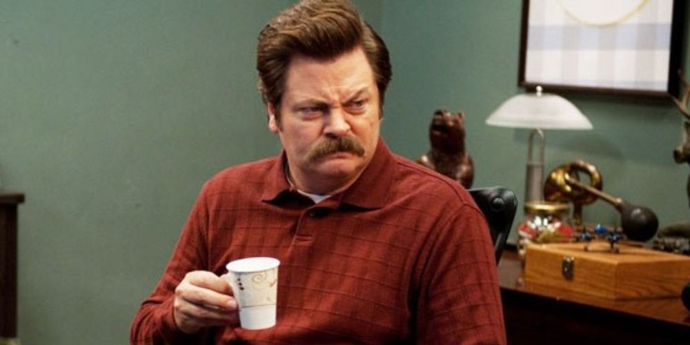 Ron Swanson holds a coffee cup in Parks and Recreation