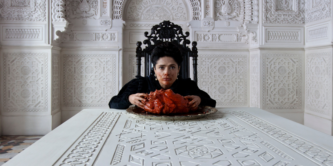 Salma Hayek eating meat on white table in a still from Tale of Tales