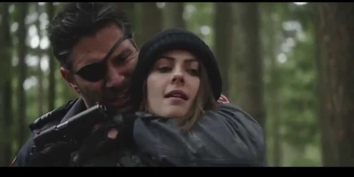 Slade holding Thea against him with a gun during their fight on Arrow