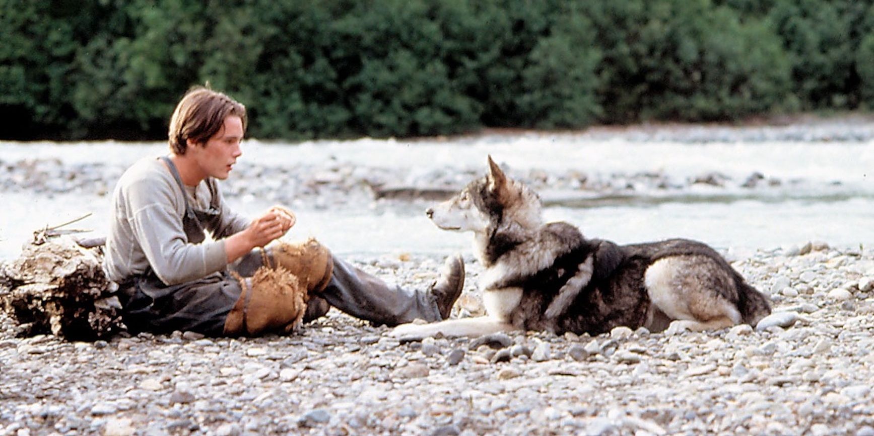 Ethan Hawke sitting on ground with White Fang