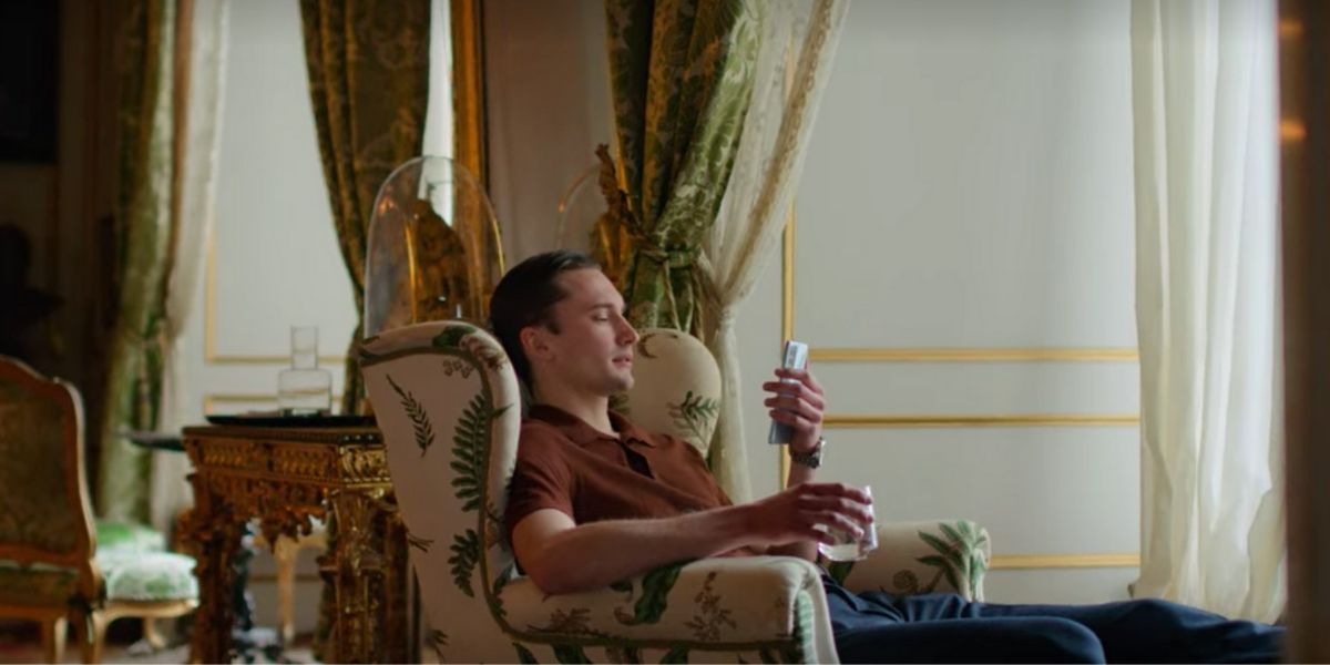 Erik sitting in a chair at the palace in Young Royals