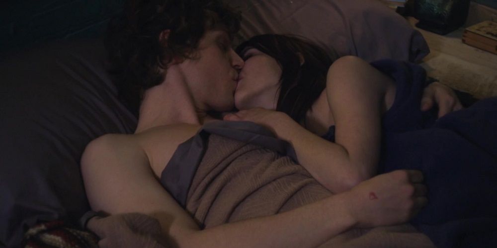 Amy and Alex kiss in bed in Adult World