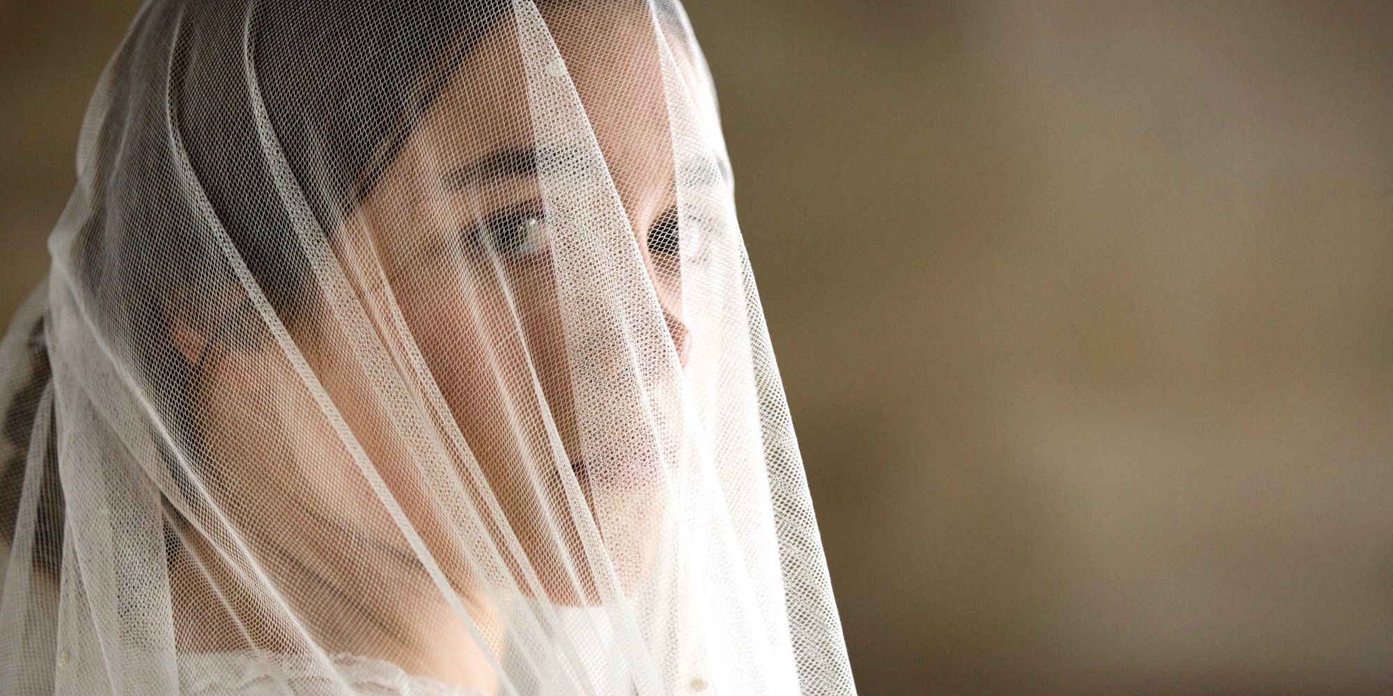 Florence Pugh wearing a veil and looking sideways in a still from Lady Macbeth 