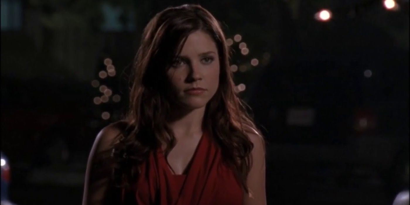 Brooke Davis parece zangada do lado de fora à noite enquanto assiste Lucas e Peyton caminharem juntos