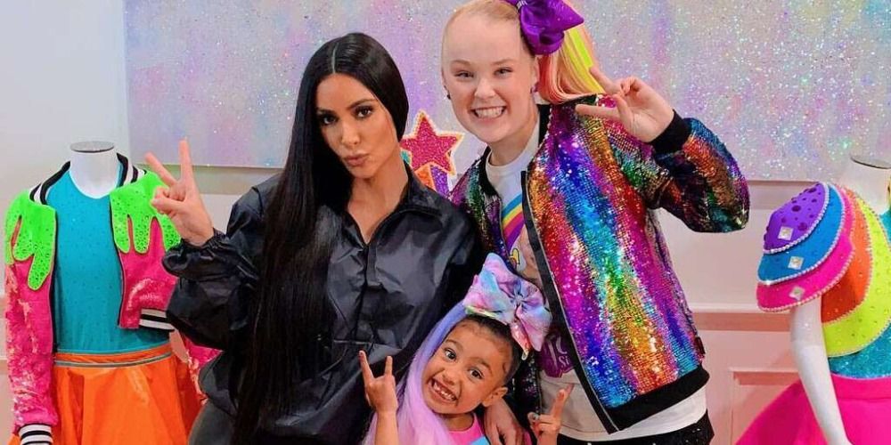 Kim Kardashian, North West, and JoJo Siwa making the peace sign in Keeping Up With The Kardashians