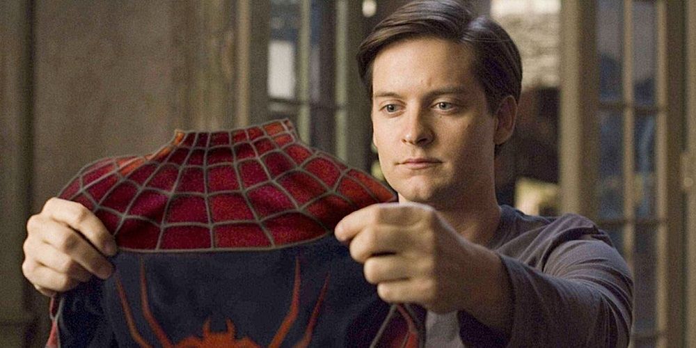 Peter Parker holds up Spidey suit in Spider-Man