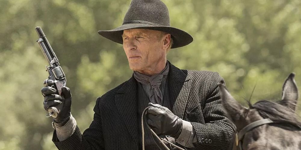 the Man in Black from Westworld holding a gun and riding a horse