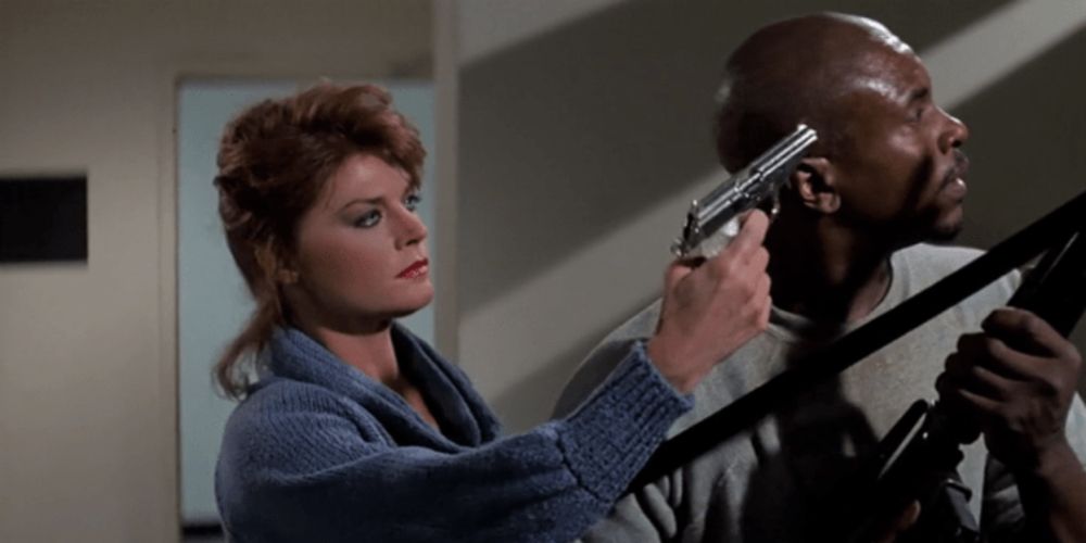 Holly points gun at Frank in They Live