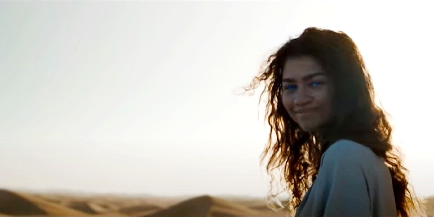 Chani looking back and smiling in the desert in Dune (2021).