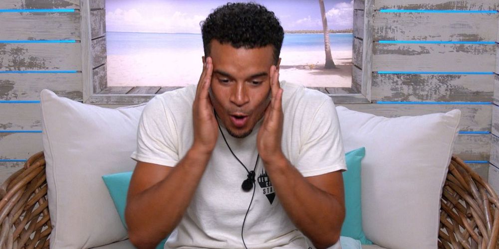 Toby rubs his temples in the confessional booth on Love Island