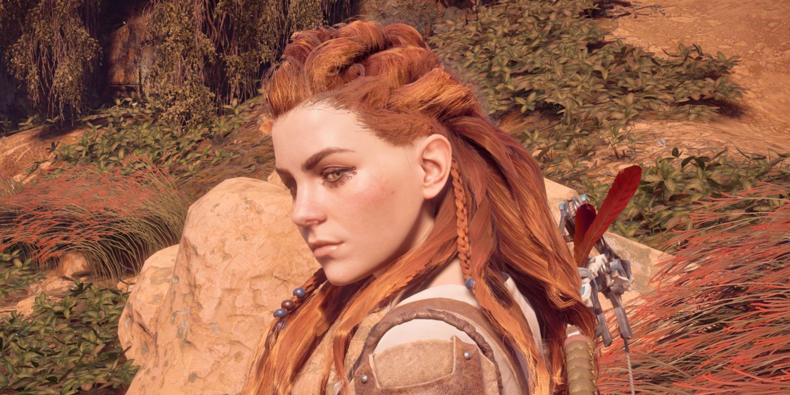 Aloy looks to her side in the wild desert in the video game Horizon Zero Dawn.