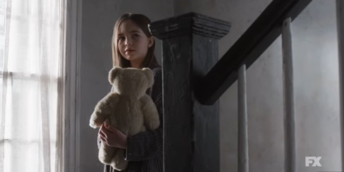 Une jeune fille tenant un ours en peluche dans AHS : Double Feature