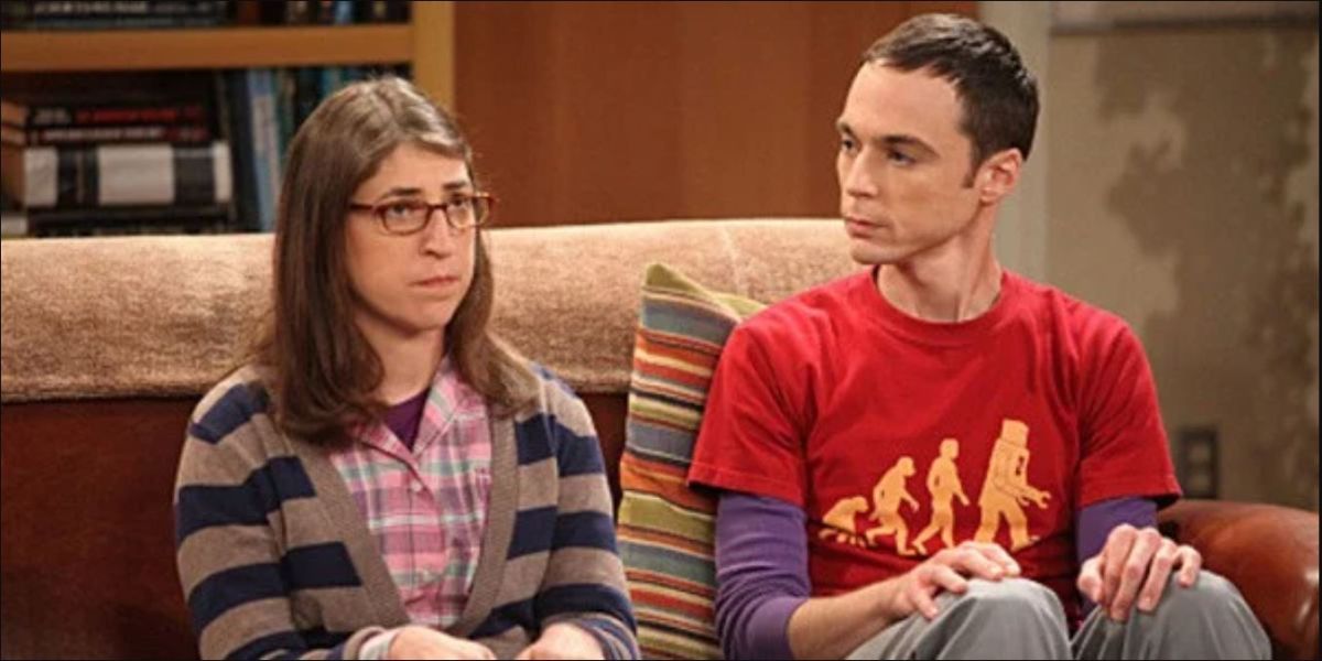 Amy and Sheldon sitting on the couch in his apartment with Sheldon staring at Amy and Amy looking straight ahead on TBBT