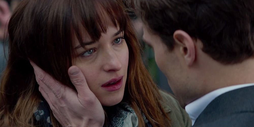 Anastasia and Christian in Fifty Shades of Grey, Christian is touching Ana’s face