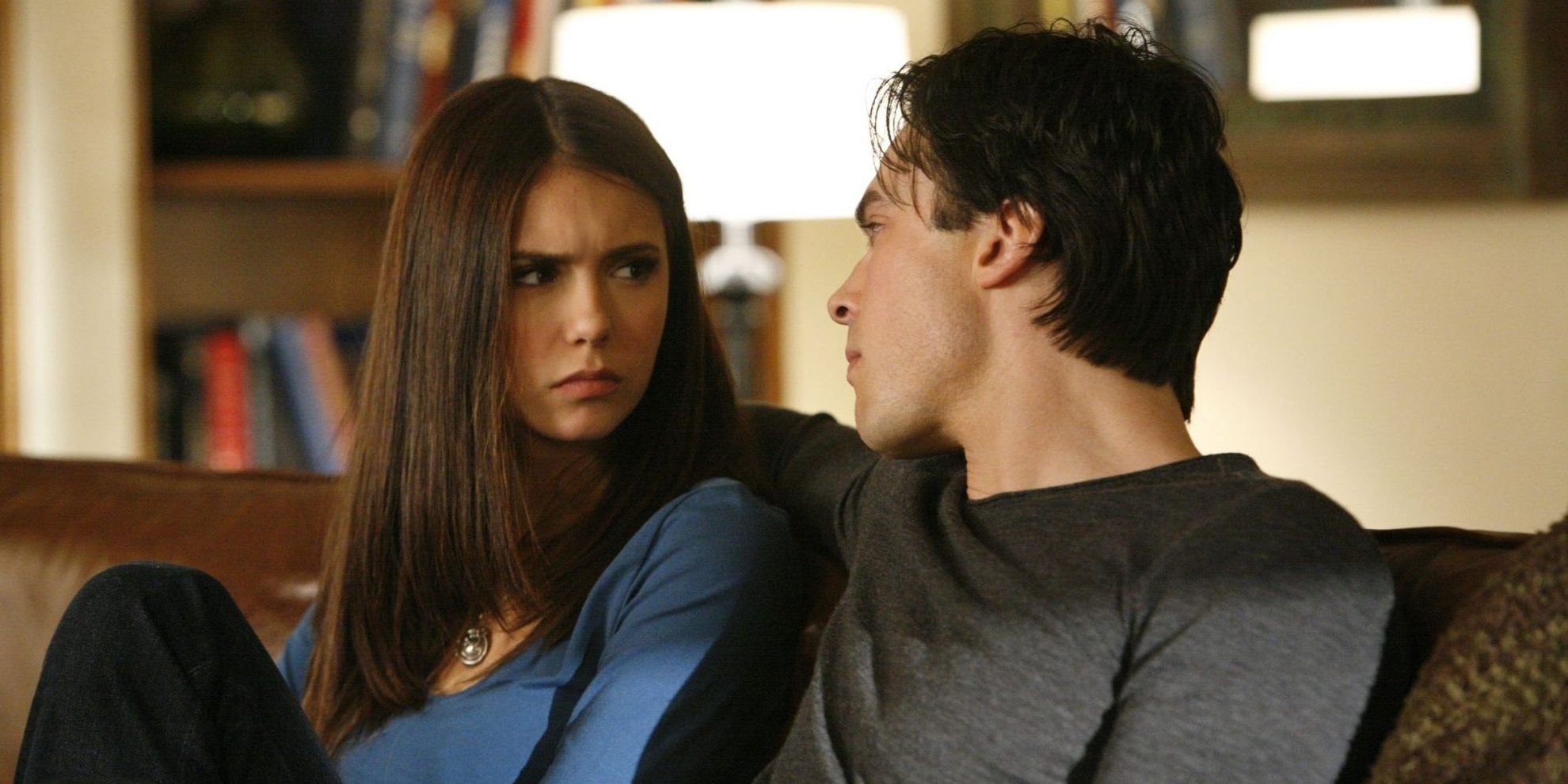 Elena and Damon sitting on the couch in The Vampire Diaries.