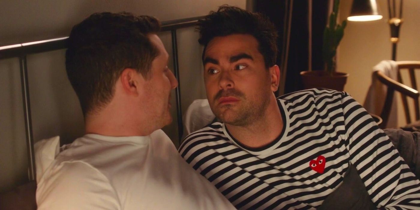 David lying in bed with Patrick in an episode of Schitt's Creek