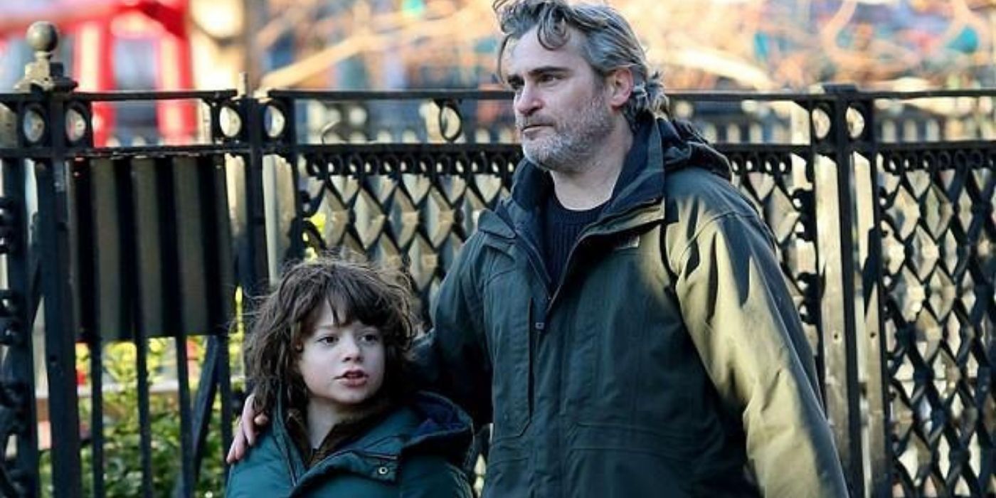 Joaquin Phoenix and a child actor walking side by side in the upcoming movie Disappointment Blvd.