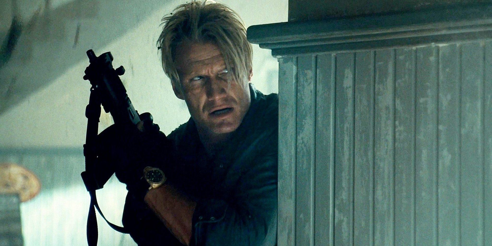 Gunner (Dolph Lundgren) hiding behind wall with gun in The Expendables