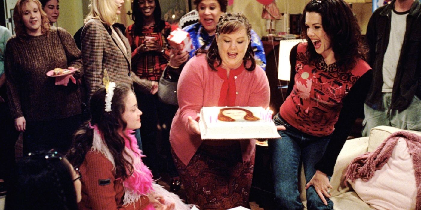 Sookie holding a birthday cake with Rory and Lorelai at Rory's birthday on Gilmore Girls