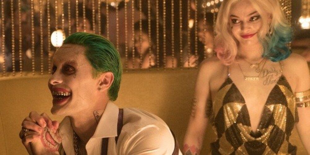 Joker begs offscreen while Harley smiles