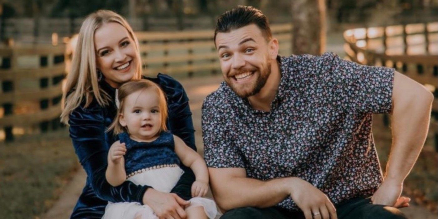 Libby Potthast, Andrei Castravet, and daughter Eleanor from 90 Day Fiancé: Happily Ever After posing in front of fence