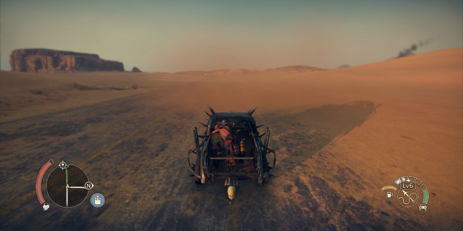 An image of Mad Max on the back of his car driving through the Wasteland in the video game Mad Max.