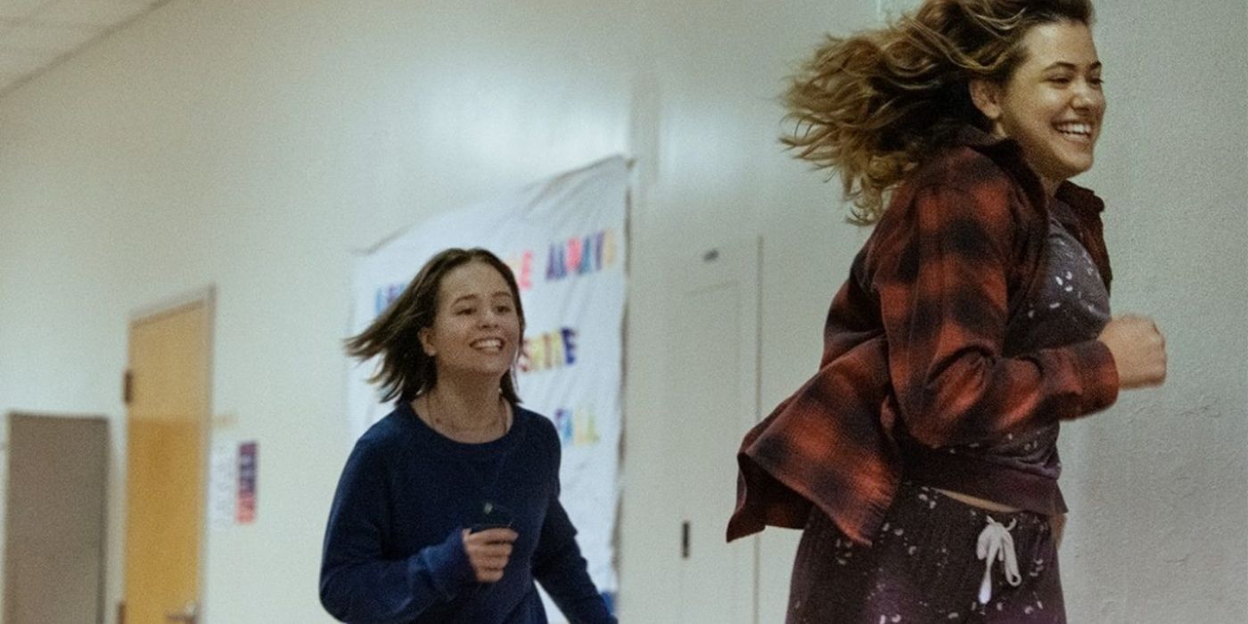 Two girls laughing and running through a hallway in Modern Love season 2.
