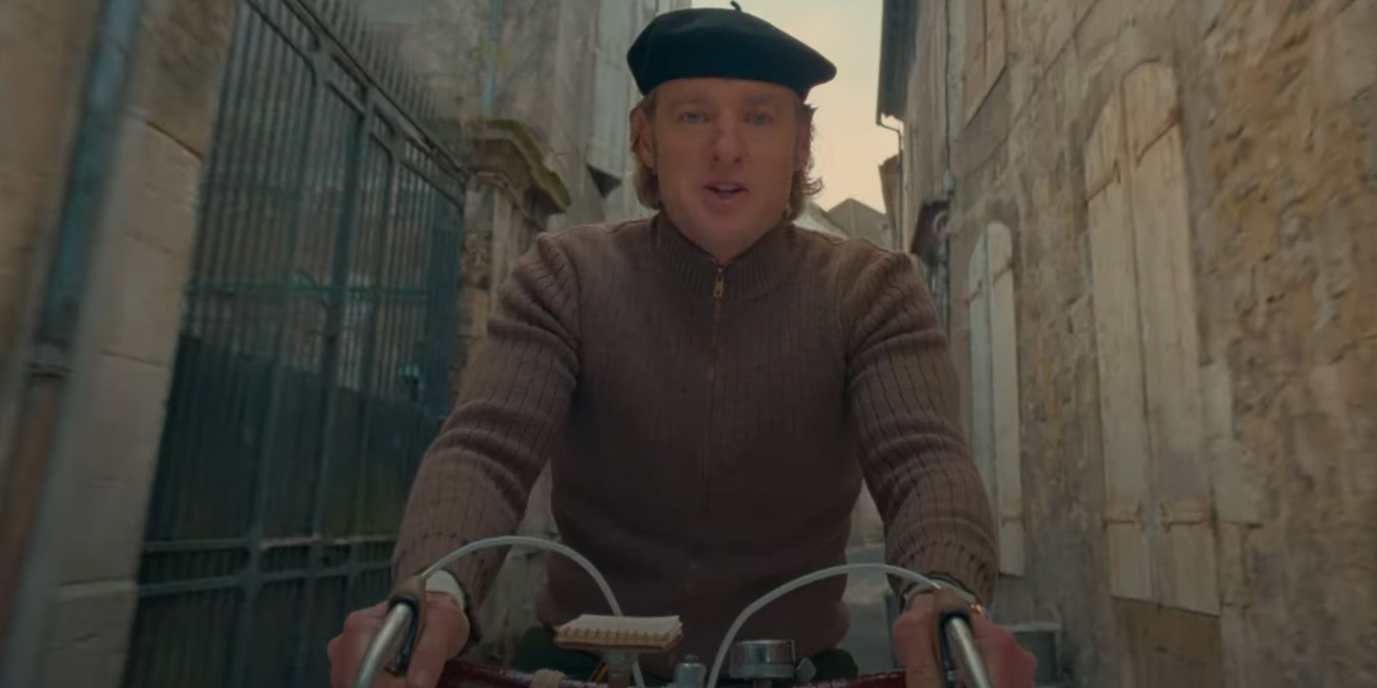 Owen Wilson riding a bike in The French Dispatch