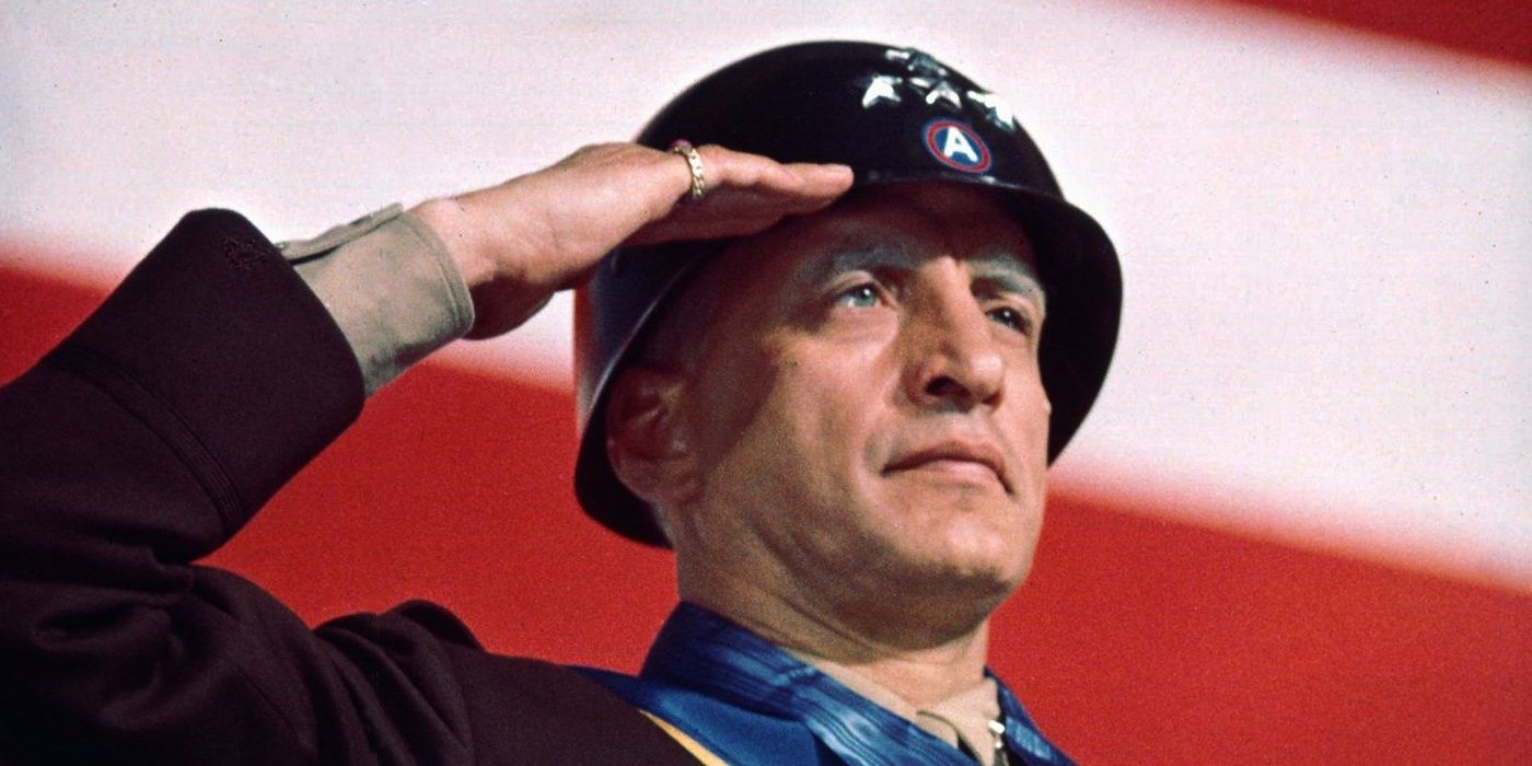 Patton saluting in front of a flag