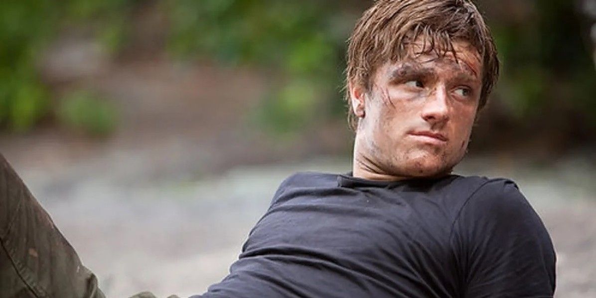 Peeta laying on a rock in the Arena in The Hunger Games series.