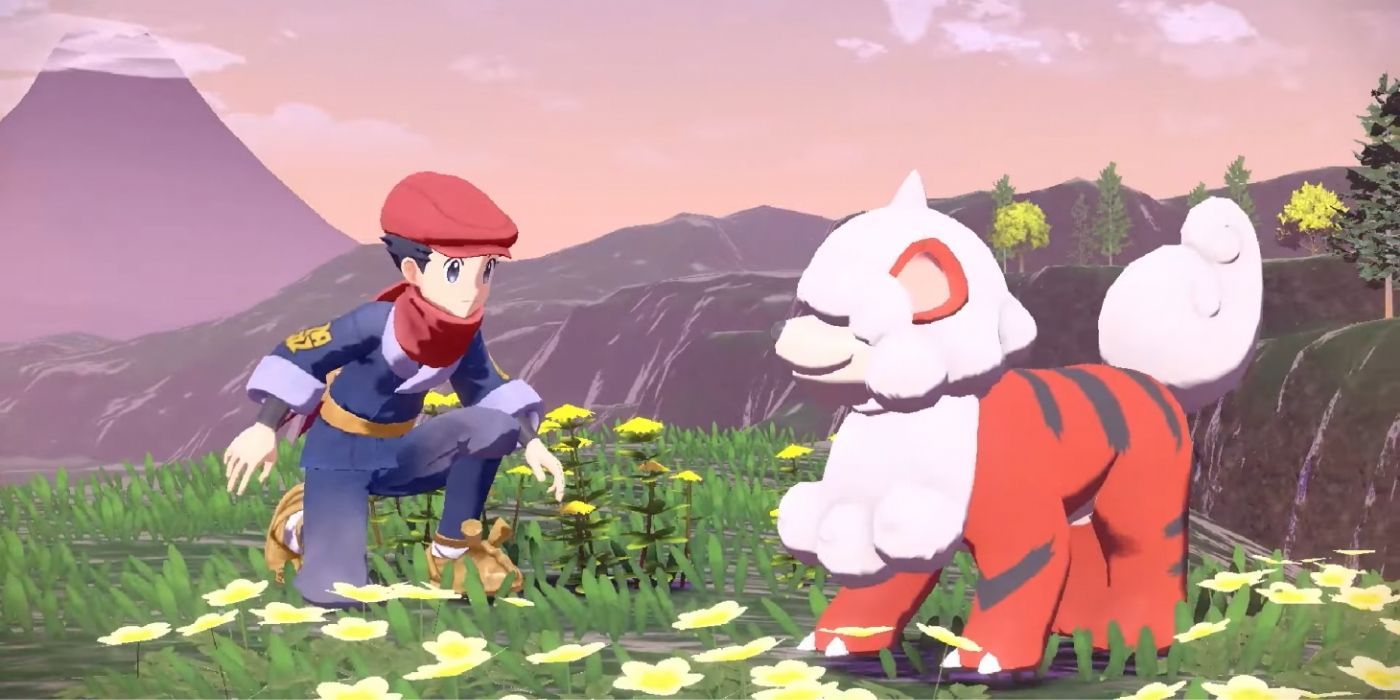 The player character kneels in front of a Hisuian Growlithe in Pokémon Legends: Arceus.