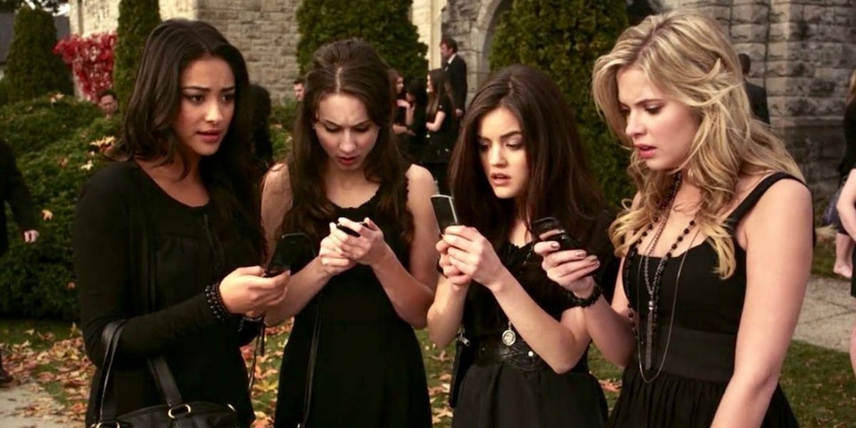 Emily, Spencer, Aria, and Hanna looking at phones on Pretty Little Liars