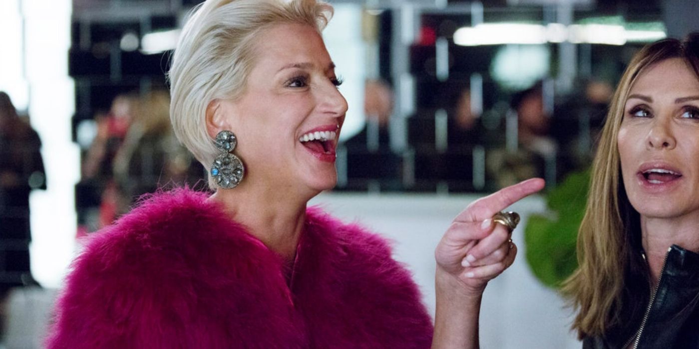 Dorinda in a red sweater laughing next to Carol on RHONY