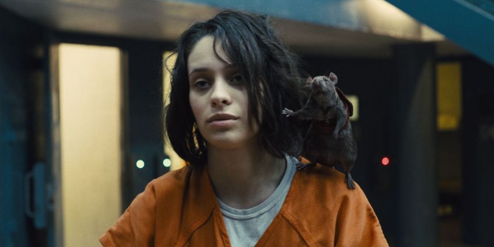 Ratcatcher 2 in an orange prison uniform, Sebastian the rat is on her shoulder waving, in The Suicide Squad