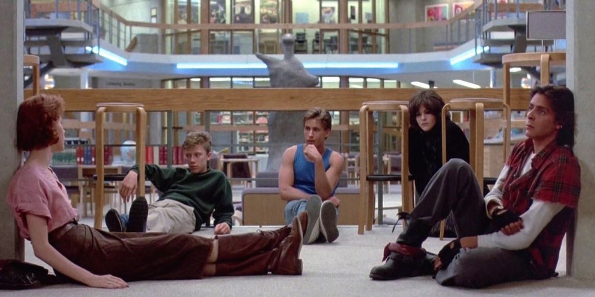 The cast of The Breakfast Club sitting on the floor in the library