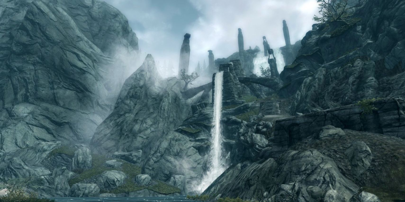 A screenshot looking up toward the summit of Skyrim's Bard's Leap, where water runs out of the ruins in a small waterfall.